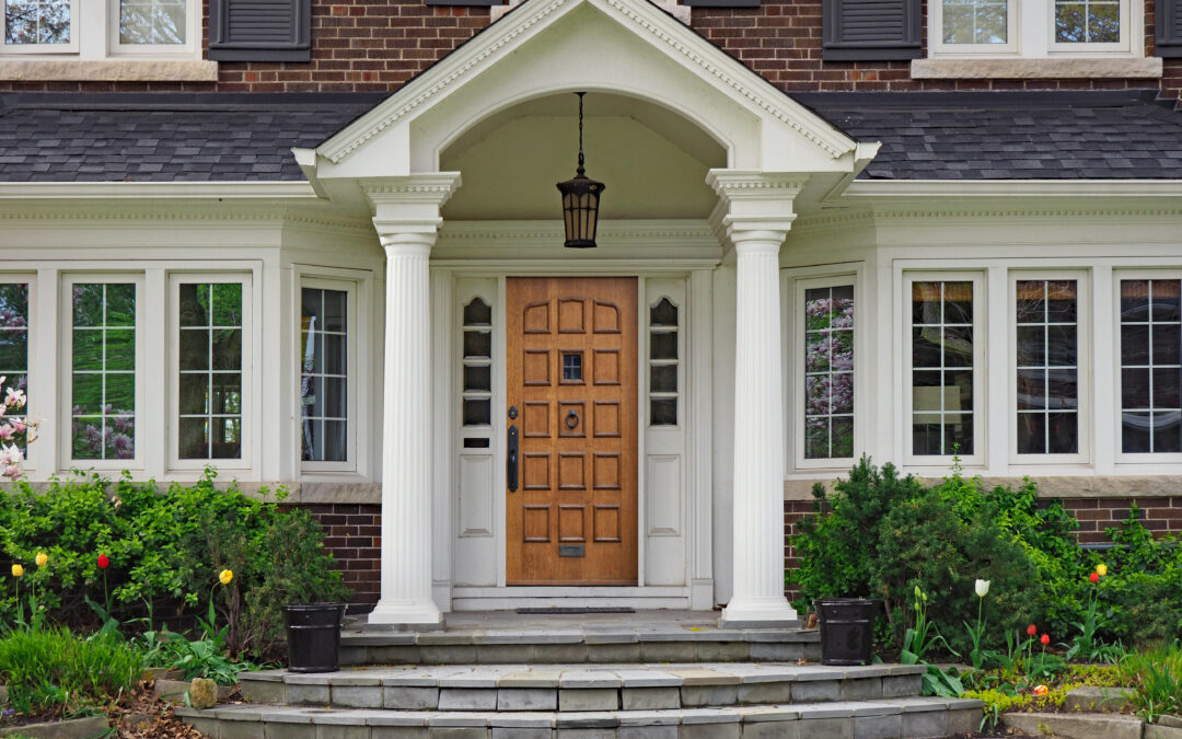 elegant wooden front door of large suburban house with gabled portico
